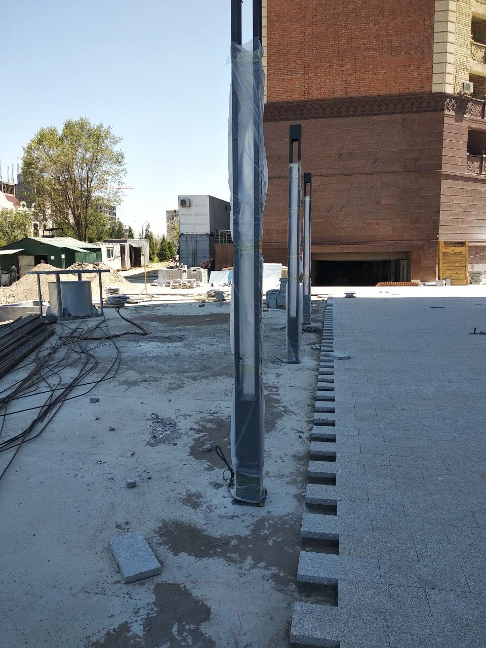 Lighting poles installed on site, still in protective film